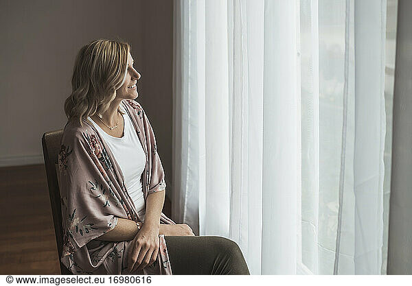 Portrait of beautiful mother in studio looking out window
