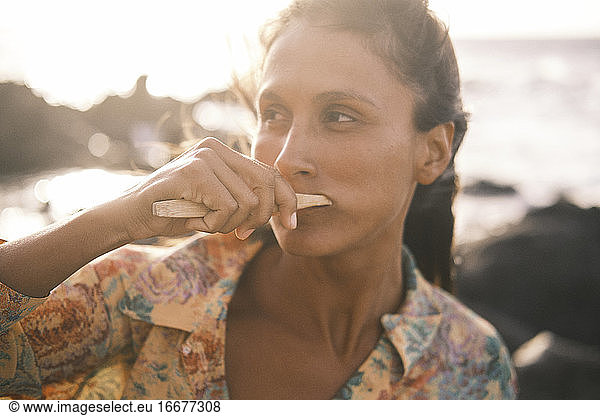 Portrait of beautiful woman brushing her teeth with bamboo toothbrush