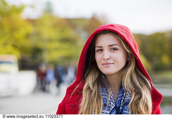 Portrait of beautiful young woman wearing hooded jacket outdoors