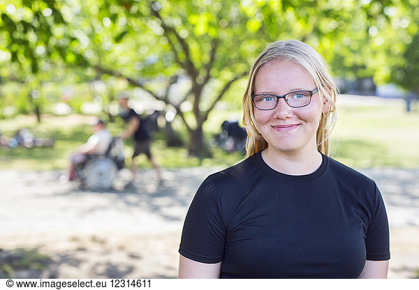 Portrait of blonde teenage girl (14-15) in park