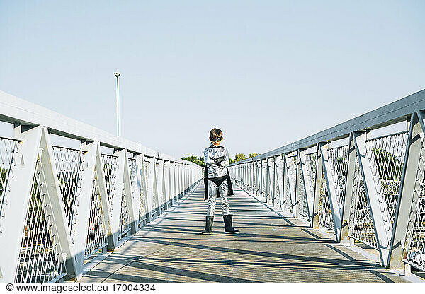 Portrait of boy disguised as superhero standing on a footbridge