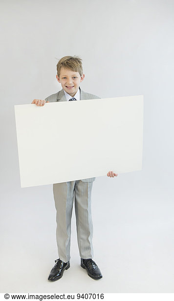 Portrait of boy holding blank whiteboard  smiling