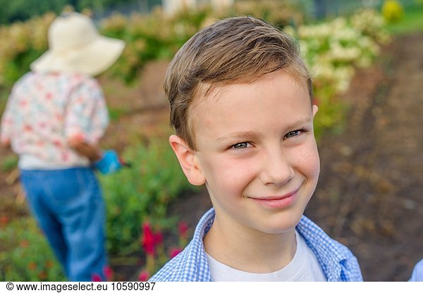 Portrait of boy in front of great grandmother on farm