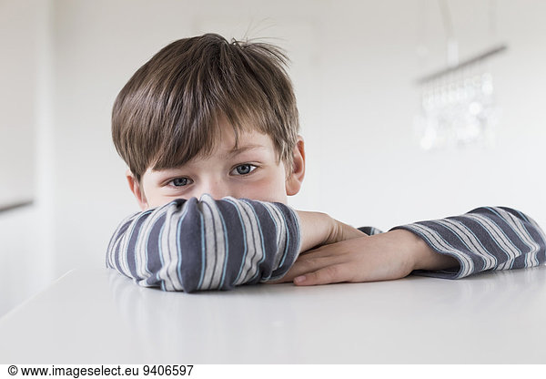 Portrait of boy leaning on table  close up