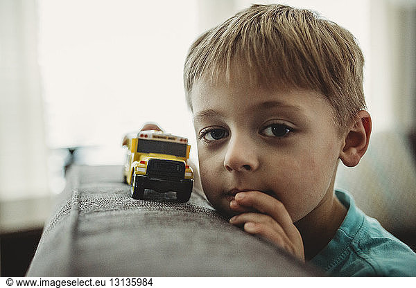 Portrait of boy playing with toy truck at home