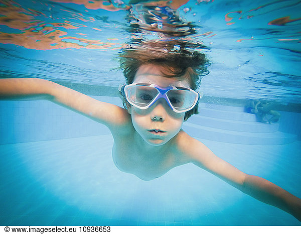 Portrait of boy swimming underwater in swimming pool