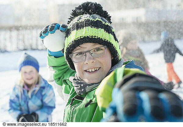 Portrait of boy throwing snowball