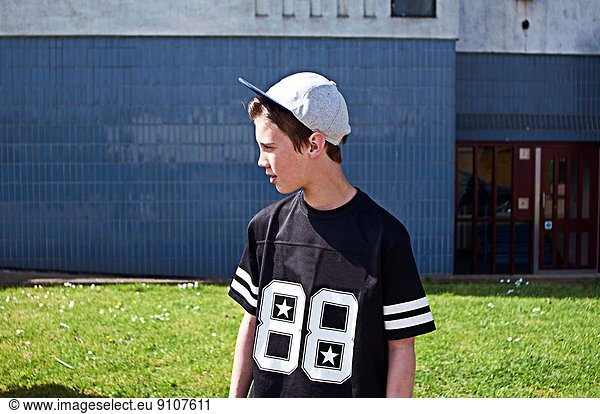 Portrait of boy wearing baseball cap looking away