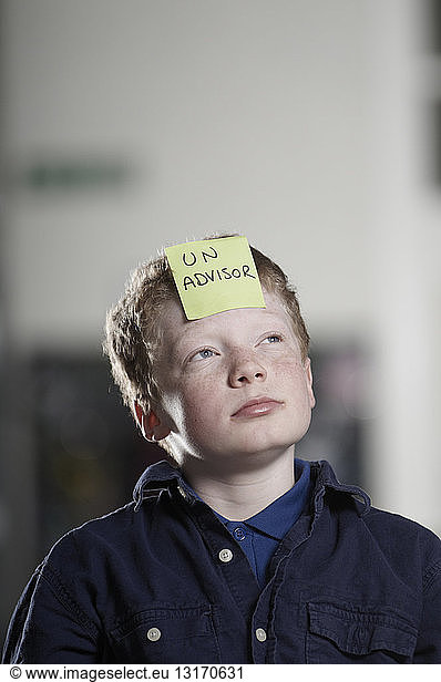 Portrait of boy with sticky note on forehead
