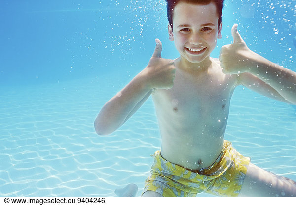 Portrait of boy with thumbs up underwater