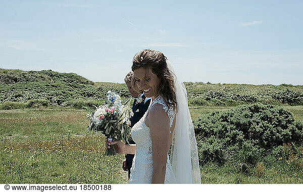 portrait of bride and groom smiling walking on a summers day