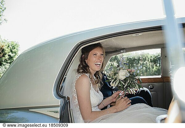 portrait of bride smiling sat with her boquet on her wedding day
