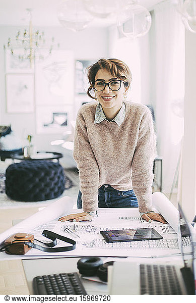 Portrait of business woman standing at table working at home