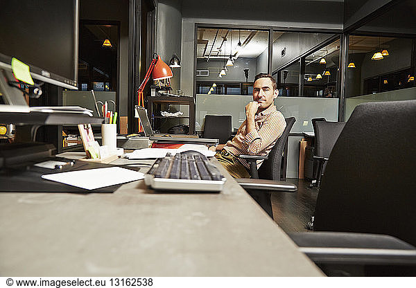 Portrait of businessman sitting at desk in office