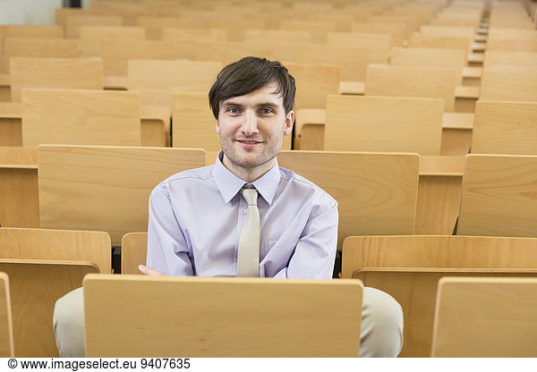 Portrait of businessman sitting in auditorum  smiling