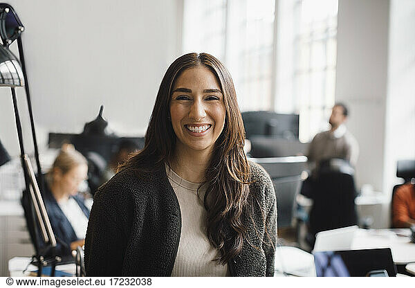 Portrait of businesswoman laughing in creative office