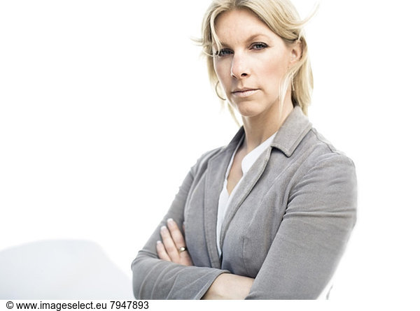 Portrait of businesswoman standing arms crossed against wall