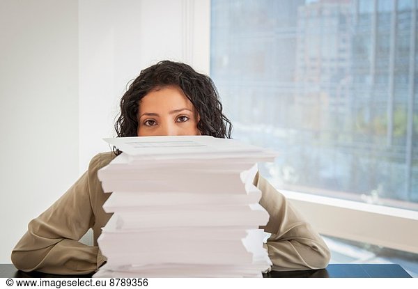 Portrait of businesswoman with a stack of paperwork