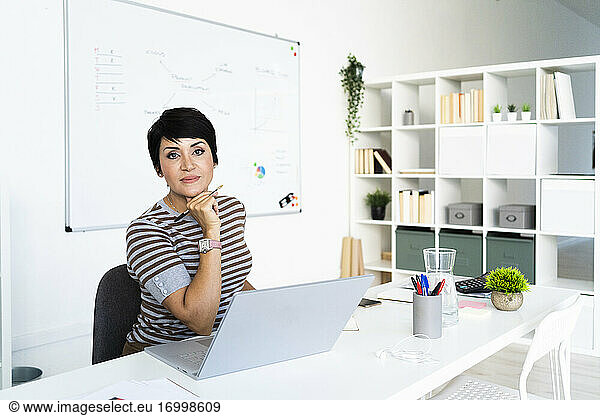 Portrait of businesswoman working at office in front of laptop