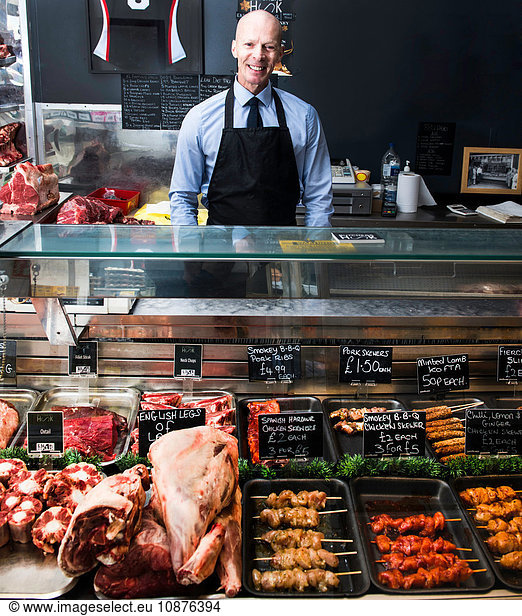 Portrait of butcher  standing behind counter