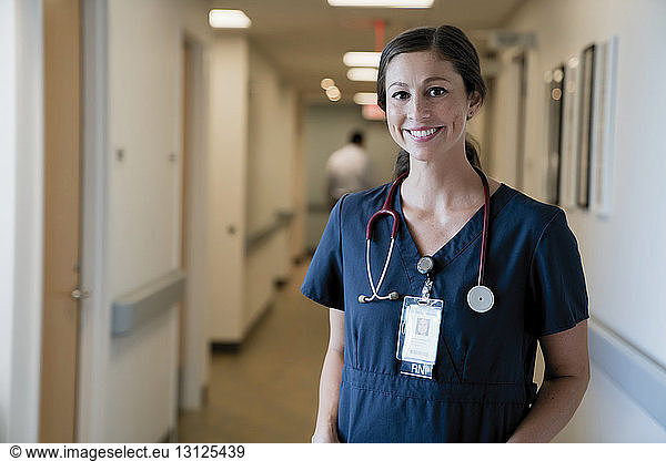 Portrait of cheerful female doctor standing in hospital lobby