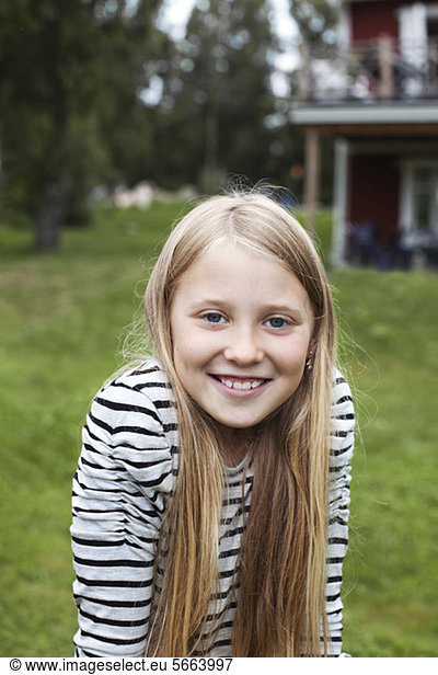 Portrait of cheerful girl enjoying in back yard