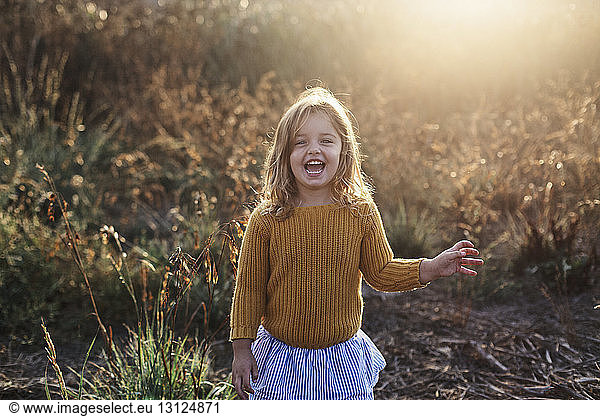Portrait of cheerful girl with mouth open standing at farm