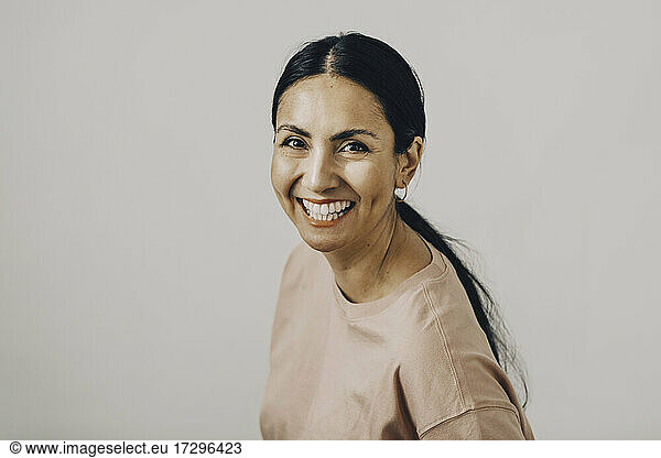 Portrait of cheerful mid adult woman against white background
