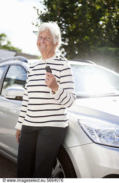 Portrait of cheerful senior woman showing car key