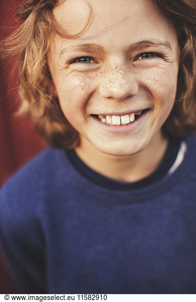 Portrait of cheerful teenage boy in back yard