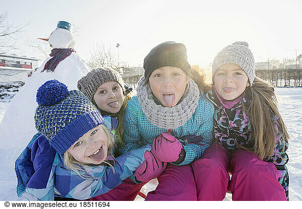 Portrait of children sticking out tongue