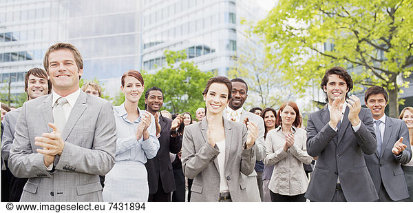 Portrait of clapping business people in crowd