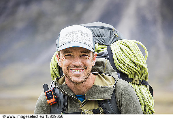 Portrait of climber wearing backpack  rope and GPS communication tool
