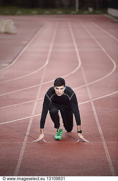 Portrait of confident athlete at starting line