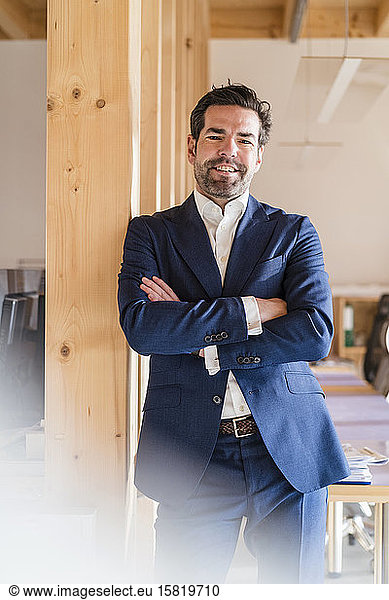 Portrait of confident businessman in wooden open-plan office