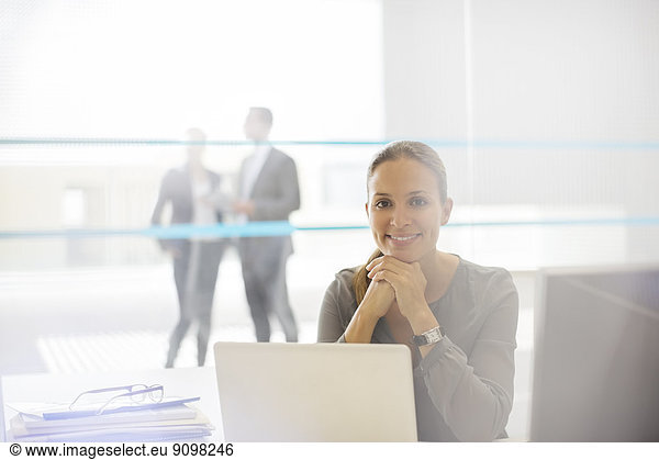 Portrait of confident businesswoman at laptop in office
