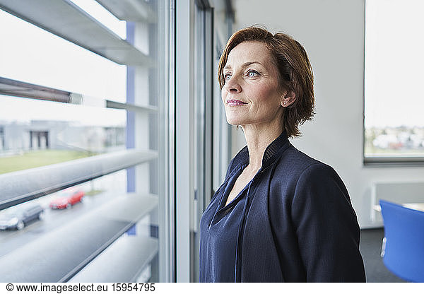 Portrait of confident businesswoman looking out of window