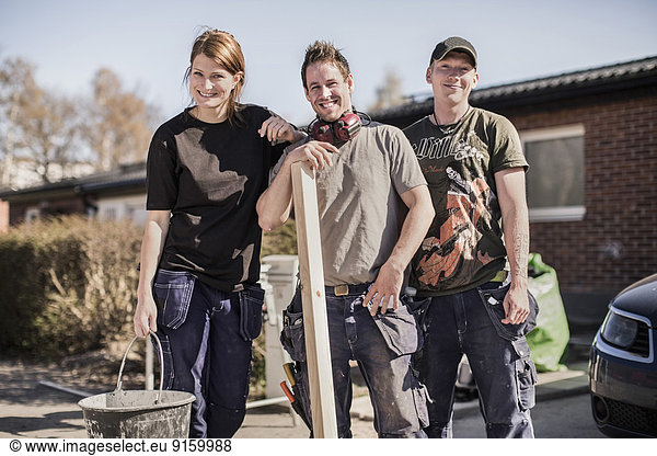 Portrait of confident carpenters standing at construction site