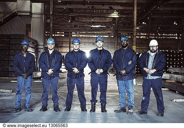 Portrait of confident colleagues in factory warehouse
