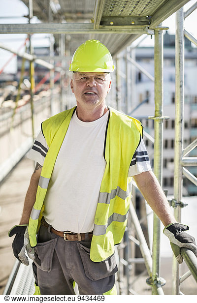 Portrait of confident construction worker standing at site