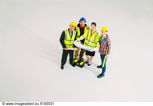 Portrait of confident construction workers with blueprints