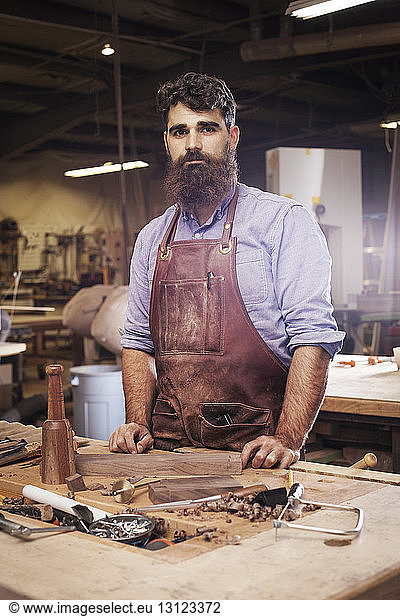 Portrait of confident Craftsman standing at wood shop