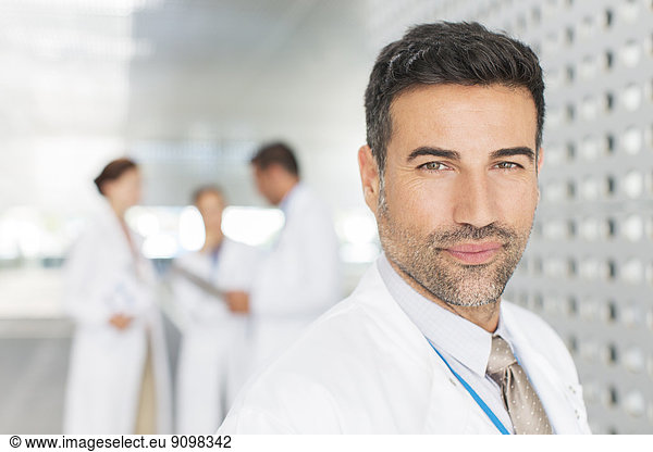 Portrait of confident doctor in hospital corridor