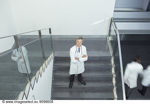 Portrait of confident doctor on staircase