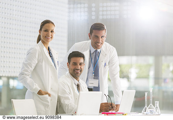 Portrait of confident doctors working at laptop