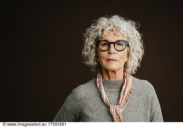 Portrait of confident elderly woman in studio