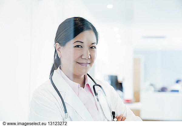 Portrait of confident female doctor in hospital seen though window