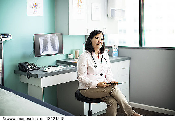 Portrait of confident female doctor sitting in clinic