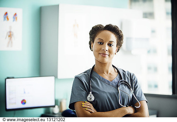 Portrait of confident female doctor standing arms crossed in clinic