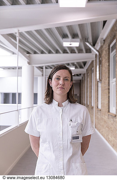 Portrait of confident female doctor standing in hospital corridor